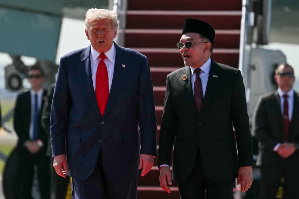 U.S. President Donald Trump speaks with Malaysia's Prime Minister Anwar Ibrahim as he walks from Air Force One upon arrival at Kuala Lumpur International Airport on Sunday. U.S. President Donald Trump speaks with Malaysia's Prime Minister Anwar Ibrahim as he walks from Air Force One upon arrival at Kuala Lumpur International Airport on Sunday.