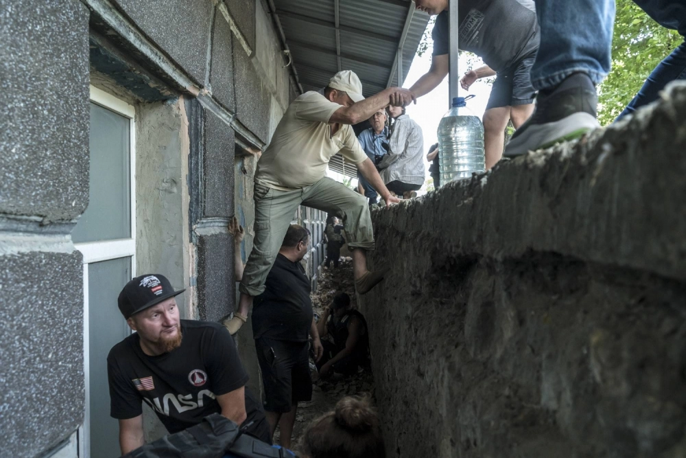 People take cover near the scene of a shelling in Kherson, Ukraine, on June 8, 2023. People take cover near the scene of a shelling in Kherson, Ukraine, on June 8, 2023.