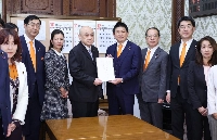 Sanseito leader Sohei Kamiya (center right) and others submit a bill to revise the Panel Code to House of Councilors Secretary-General Fumitake Kobayashi (center left) at parliament on Monday. | JIJI