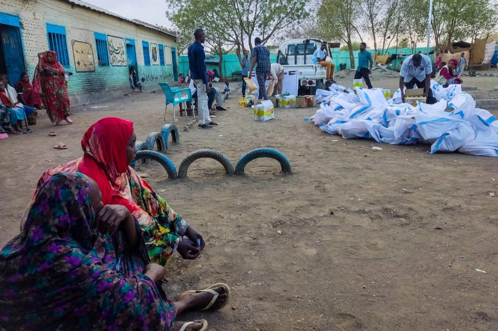 Internally displaced women wait to collect aid at a displacement camp in Gadaref, Sudan. Internally displaced women wait to collect aid at a displacement camp in Gadaref, Sudan.