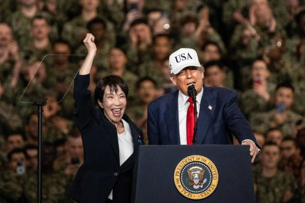 Prime Minister Sanae Takaichi raises her fist as U.S. President Donald Trump delivers a speech in front of U.S. Navy personnel on board the U.S. Navy's USS George Washington aircraft carrier at the American naval base in Yokosuka, Kanagawa Prefecture, on Tuesday. Prime Minister Sanae Takaichi raises her fist as U.S. President Donald Trump delivers a speech in front of U.S. Navy personnel on board the U.S. Navy's USS George Washington aircraft carrier at the American naval base in Yokosuka, Kanagawa Prefecture, on Tuesday.