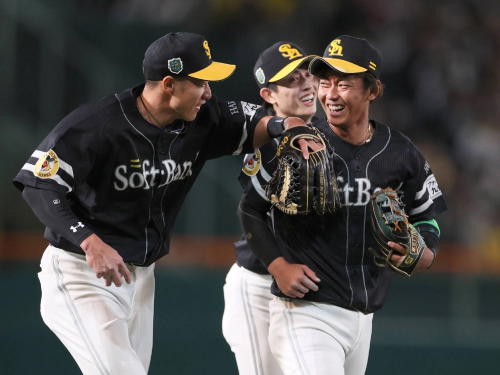 SoftBank shortstop Imamiya (right) celebrates after making a catch off Hanshin's Sakamoto's hit in the sixth inning at Koshien Stadium on Tuesday. SoftBank shortstop Imamiya (right) celebrates after making a catch off Hanshin's Sakamoto's hit in the sixth inning at Koshien Stadium on Tuesday.