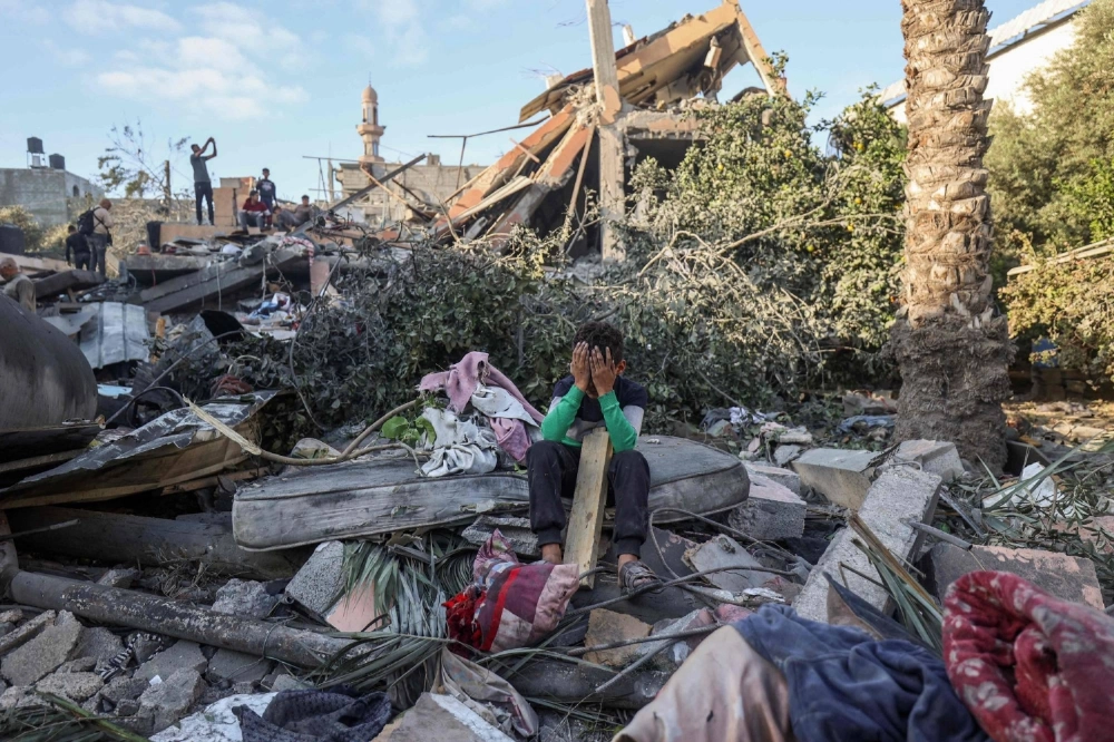 A boy sits amid the rubble of a house destroyed in an Israeli strike in Nuseirat, in the Gaza Strip, on Wednesday. A boy sits amid the rubble of a house destroyed in an Israeli strike in Nuseirat, in the Gaza Strip, on Wednesday.