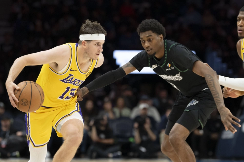 Lakers guard Austin Reaves (left) dribbles the ball past Timberwolves forward Jaden McDaniels in the second half at Target Center in Minneapolis on Wednesday. Lakers guard Austin Reaves (left) dribbles the ball past Timberwolves forward Jaden McDaniels in the second half at Target Center in Minneapolis on Wednesday.