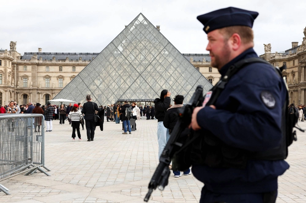 A French CRS riot police officer patrols near the glass Pyramid of the Louvre Museum in Paris on Monday. A French CRS riot police officer patrols near the glass Pyramid of the Louvre Museum in Paris on Monday.
