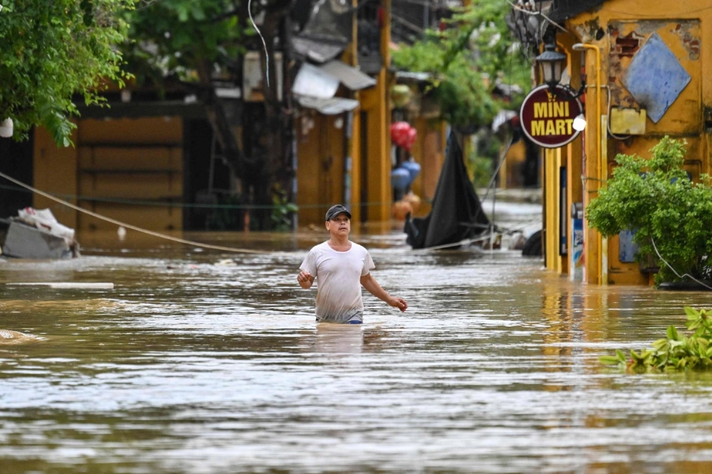 A man wades through a flooded street following heavy rain in Hoi An, Vietnam, on Thursday. A man wades through a flooded street following heavy rain in Hoi An, Vietnam, on Thursday.