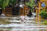 A man wades through a flooded street following heavy rain in Hoi An, Vietnam, on Thursday. | AFP-JIJI