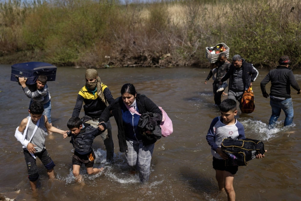People fleeing sectarian violence in Syria cross a river into northern Lebanon near the town of Masoudiyeh on March 12.  People fleeing sectarian violence in Syria cross a river into northern Lebanon near the town of Masoudiyeh on March 12.
