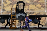 去年1月,在台灣台中舉行的年度軍事演習期間,地勤人員準備在一架台灣戰鬥機上安裝飛彈。 (路透社)