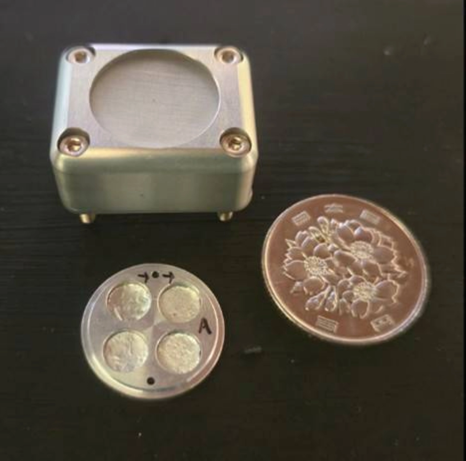 An experimental device for exposing moss spores to space, with a ¥100 coin to compare the size An experimental device for exposing moss spores to space, with a ¥100 coin to compare the size