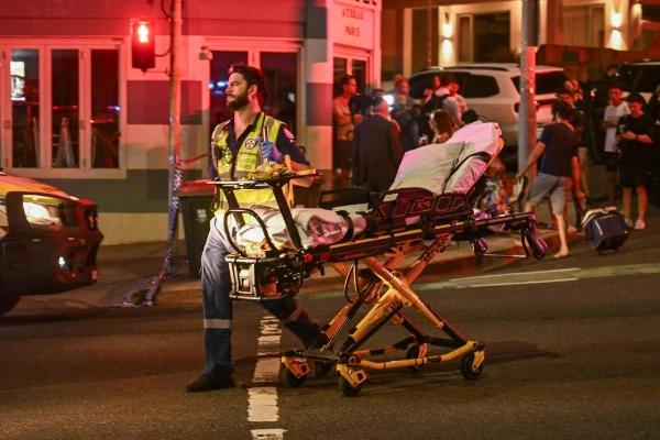 Medical personnel move a stretcher after a shooting incident at Bondi Beach in Sydney on Sunday. Australian police said two people were in custody following reports of multiple gunshots.