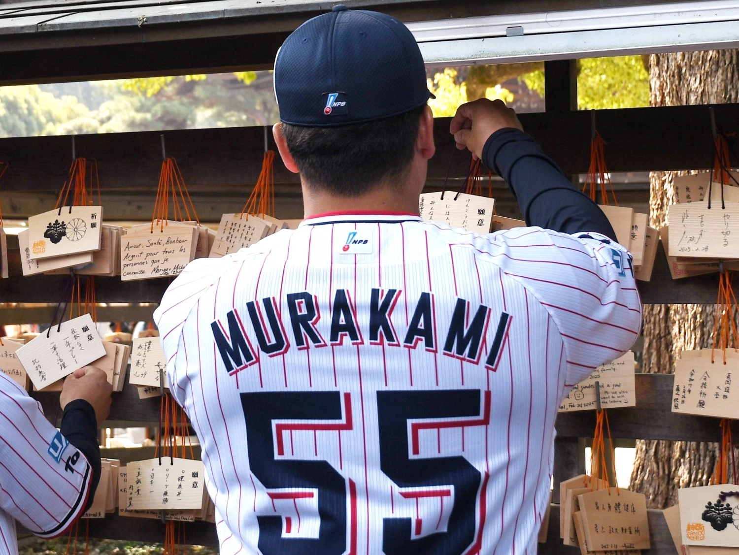 Swallows slugger Munetaka Murakami, who recently signed with the White Sox in MLB, hangs an ema at Meiji Jingu in Tokyo in February.
