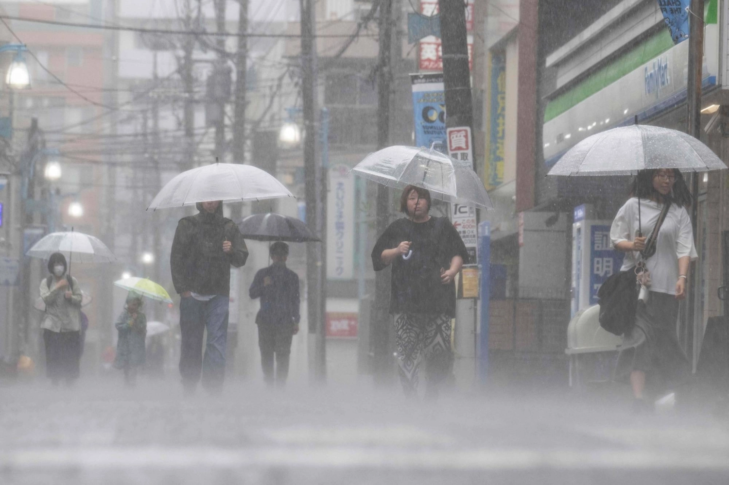People commute in heavy rain brought by Tropical Storm Jangmi in Kawasaki on Wednesday.