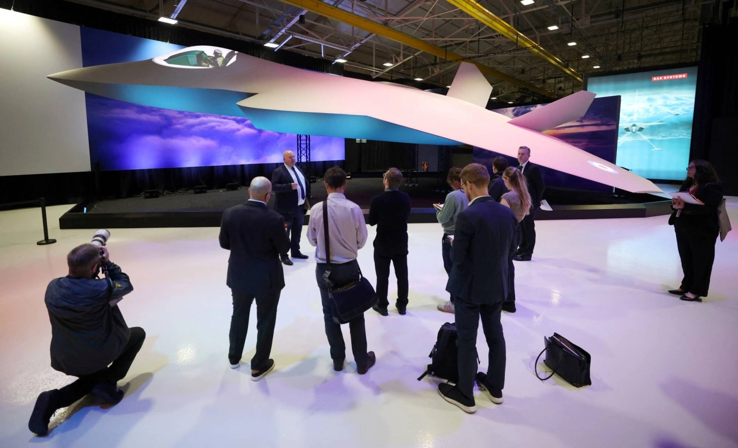 Journalists stand next to a concept model of the new Global Combat Air Program next-generation fighter jet at the BAE Systems Warton factory in Warton, England, last July. Journalists stand next to a concept model of the new Global Combat Air Program next-generation fighter jet at the BAE Systems Warton factory in Warton, England, last July.