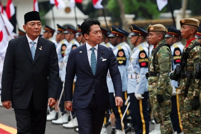 Defense Minister Shinjiro Koizumi walks with his Indonesian counterpart, Sjafrie Sjamsoeddin, as the two inspect an honor guard during a welcome ceremony in Jakarta on May 4.
