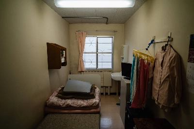 Image 23: Western-style rooms spanning the size of four tatami mats with hardwood floors, a toilet and soft mattresses on bed frames are designated for foreign nationals and those with health conditions at Tochigi Prison.