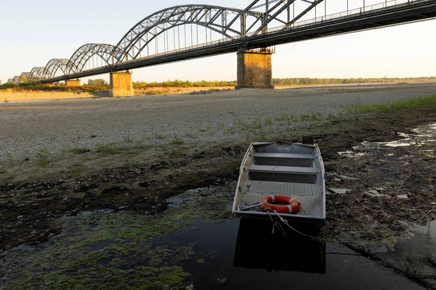 A boat is moored in shallow water near the Gerola Bridge as low water levels expose a vast gravel bank in the Po River amid a severe drought on Aug. 6. A boat is moored in shallow water near the Gerola Bridge as low water levels expose a vast gravel bank in the Po River amid a severe drought on Aug. 6.