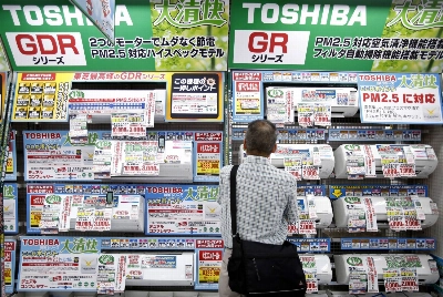A man looks at air conditioners at an electronics store in Tokyo. Being unable to meet the energy needs for a decent standard of living can negatively impact one’s mental health, opportunities for social interaction and performance at school and work.