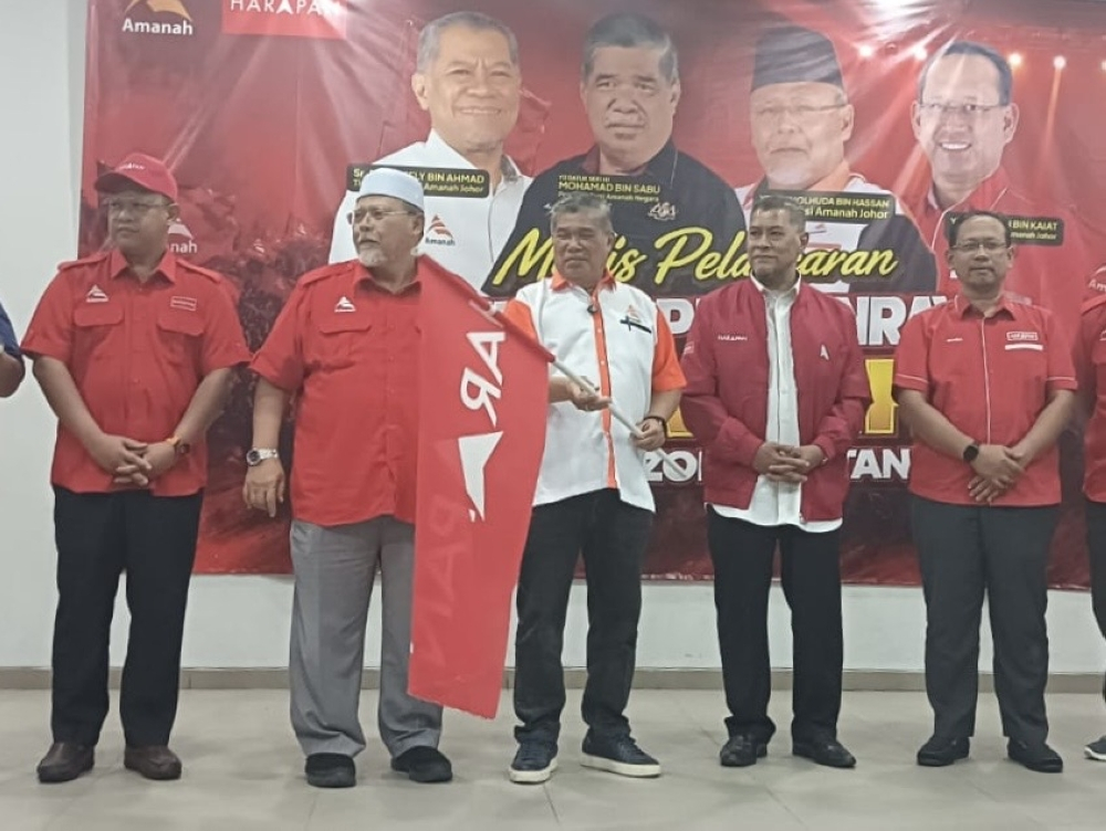Parti Amanah Negara president Datuk Seri Mohamad Sabu unfurls the Pakatan Harapan flag during the party’s southern zone election machinery launch in Taman Universiti in Johor Bahru on June 19, 2026. — Picture by Ben Tan