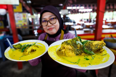 How a smoked fish curry turned a small Linggi ‘warung’ into a pilgrimage spot Warung Dayang Salai D’Linggi owner Rozianah Ahmad, 57, shows her signature smoked ‘baung’ fish dish in Port Dickson. — Bernama pic
