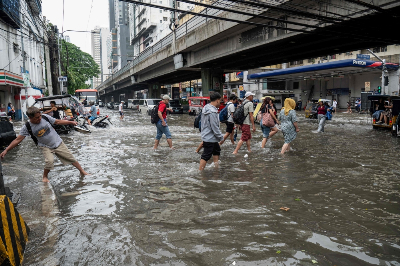 Days of heavy rain leave at least 13 dead in Philippines Pedestrians cross a flooded street after heavy rain in Manila on August 10, 2026. — AFP pic