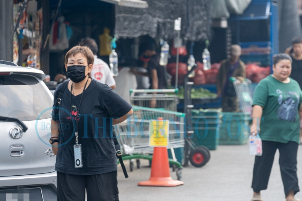 Sarawak air quality improves as Serian and Samarahan drop from unhealthy to moderate A Kuching resident shields from haze with mask, Aug 12. — The Borneo Post pic