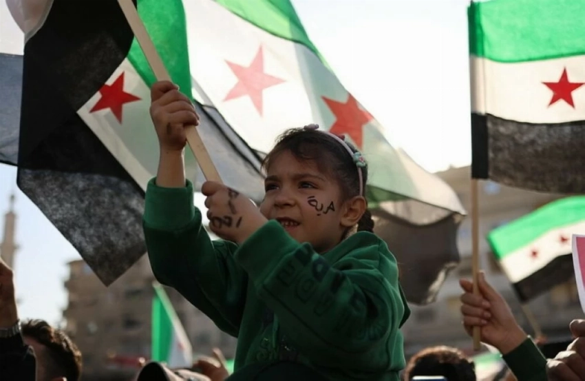 طفلة ترفع العلم السوري خلال الاحتفالات.