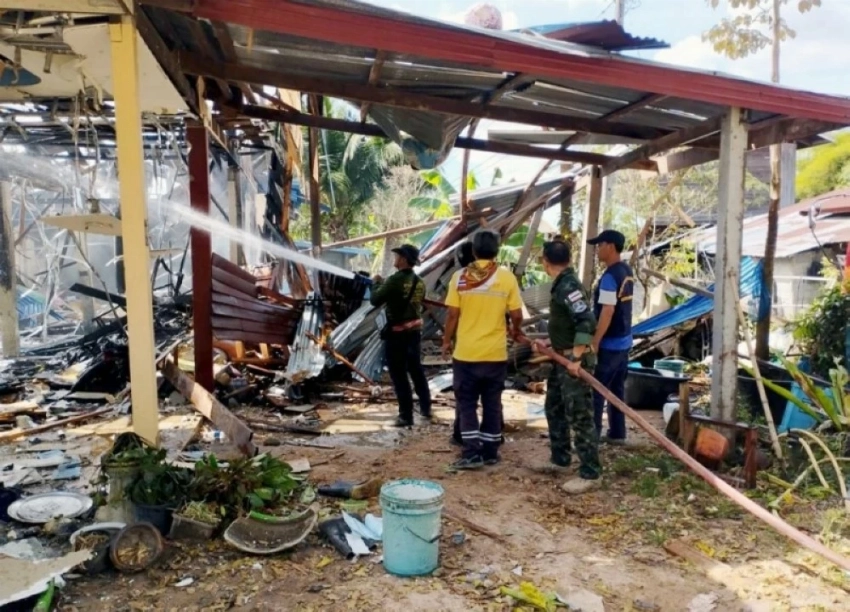 عمال الإنقاذ يقومون بإطفاء حريق في منزل بعد أن أصيب بضربات صاروخية للقوات الكمبودية. (إ ب أ)