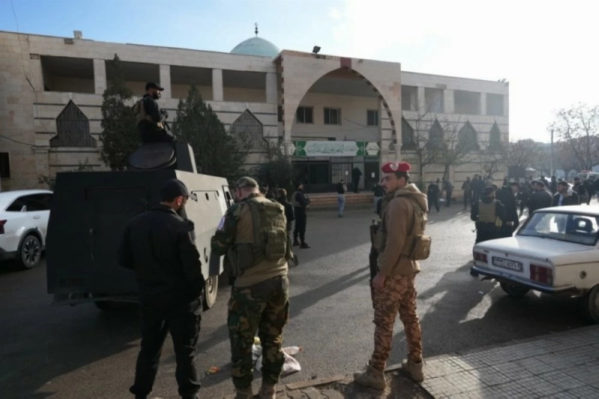 رجال الأمن خارج المسجد الذي استهدفه التفجير بحي وادي الذهب في حمص.( إ ب أ)