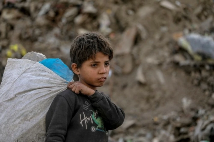 طفل فلسطيني يجمع البلاستيك في مكب للقمامة وسط مدينة غزة (إ ب أ)