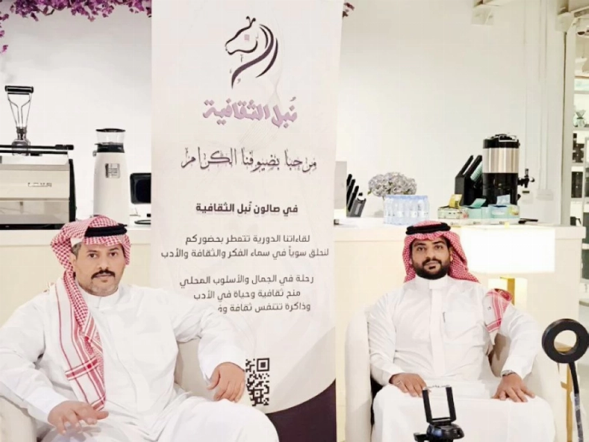 القرني قبل بدء إحدى الفعاليات الثقافية إلى جوار أسامة الواصلي.